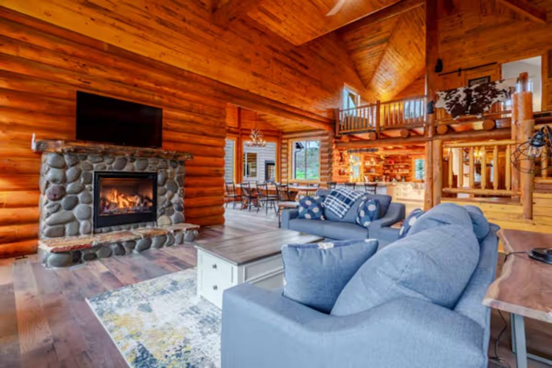 The great room with stone fireplace and log timbers